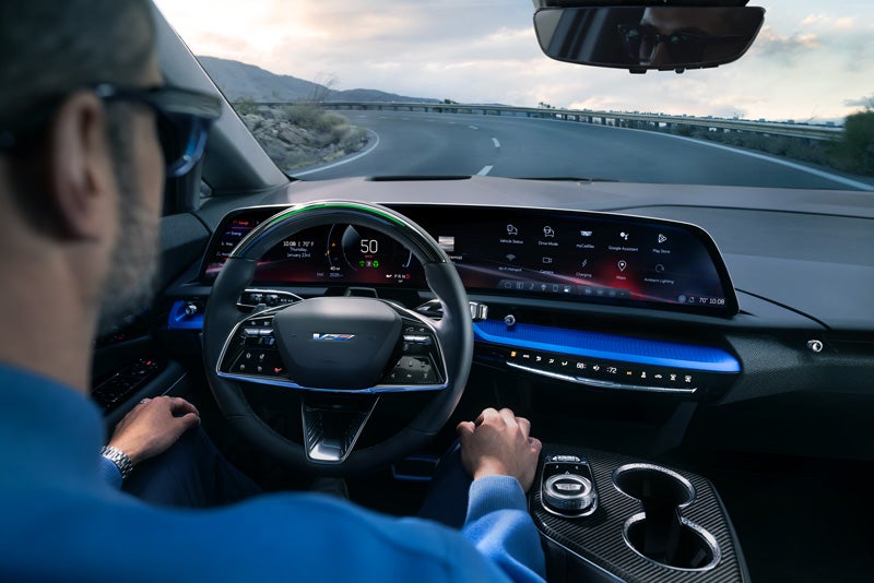 Front View of the 2026 OPTIQ-V Driving Through the Dusk Utilizing its Headlights | North Bay Cadillac in GREAT NECK NY