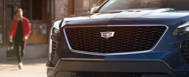 Three Quarters View of Silver, White and Red Cadillac XT6s Parked with a Sunset Behind Them