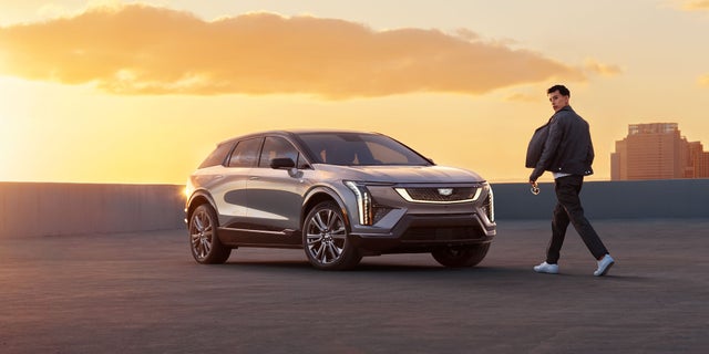 A Man Walking To a 2025 Cadillac OPTIQ During a Beautiful Sunset